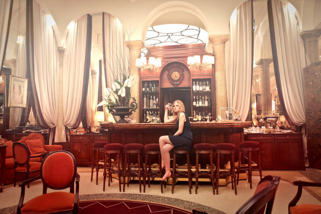 a bar in phoenix with a woman sitting in the table and drinking some wine