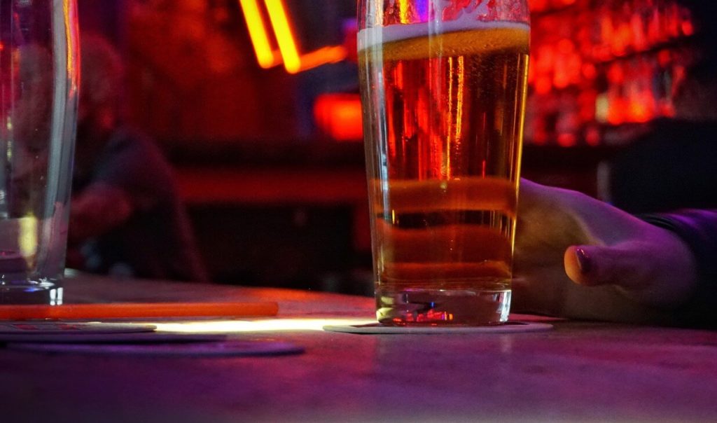 a lady in a pub in jacksonville florida drinking some beer