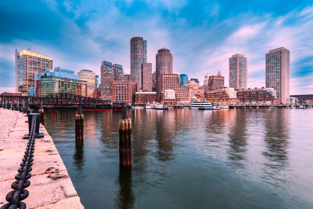 a view of boston city with buildings and the sea